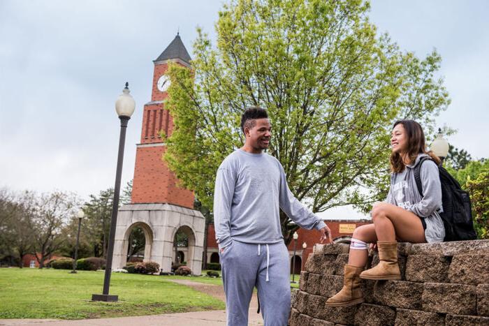 Two students talking in an outside space of the A&M-Commerce campus at Navarro College.